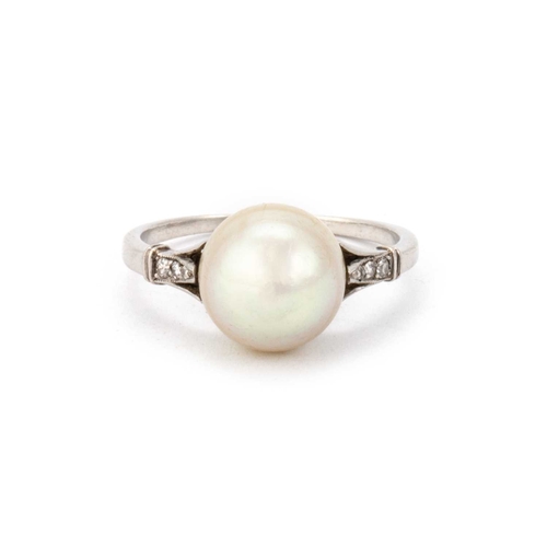 606 - A NATURAL SALTWATER PEARL RING set with a semi-baroque cream pearl,9.6 x 9.8mm, with diamond set sho... 