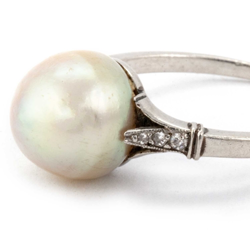 606 - A NATURAL SALTWATER PEARL RING set with a semi-baroque cream pearl,9.6 x 9.8mm, with diamond set sho... 