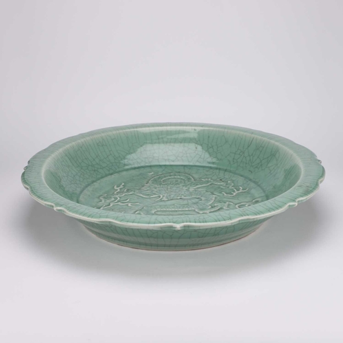 122 - A LARGE CHINESE CELADON 'DRAGON' DISH decorated in low relief with a dragon. 54cm diameterNo chips, ... 