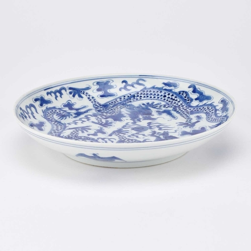 164 - A CHINESE BLUE AND WHITE 'DRAGON' DISH painted with two dragons and the flaming pearl, the underside... 