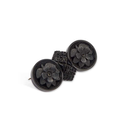 114 - A VICTORIAN CARVED JET BROOCH carved with two flowerheads within circles, on a base metal pin, cased... 