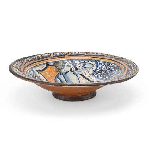 133 - A CONTINENTAL FAIENCE DISH circular, decorated in blue, orange, and green, depicting a figure, the r... 