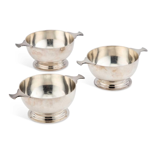 151 - A SET OF THREE SILVER-PLATED TWO-HANDLED BOWLS each in the form of a quaich. (3) 15cm longIn very go... 