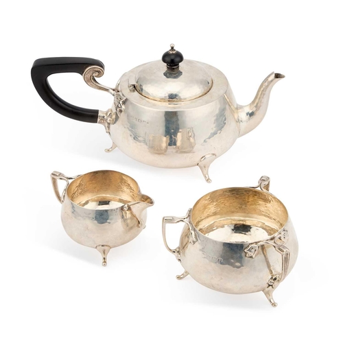 353 - AN ARTS AND CRAFTS HAMMERED SILVER THREE-PIECE TEA SERVICE maker's mark rubbed, Birmingham 1930, com... 