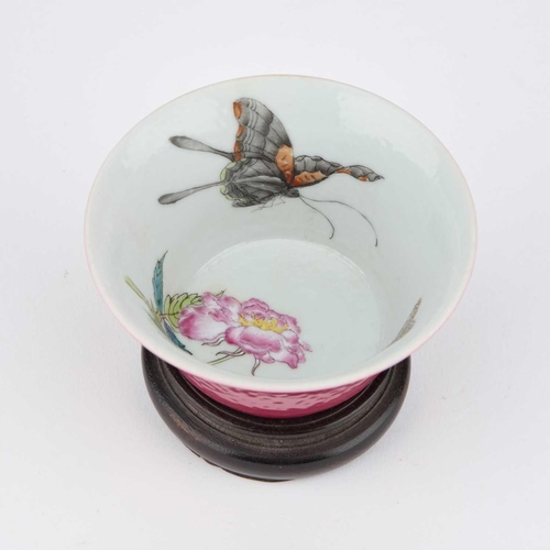 614 - A CHINESE RUBY-GROUND 'BUTTERFLY' CUP the exterior with a monochrome ruby glaze, the interior enamel... 