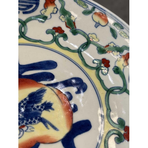 668 - A CHINESE DOUCAI BIRTHDAY DISH the centre with a finely enamelled peach enclosing a crane in flight,... 