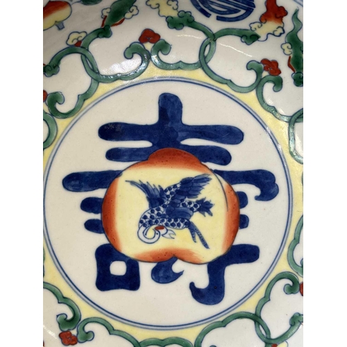 668 - A CHINESE DOUCAI BIRTHDAY DISH the centre with a finely enamelled peach enclosing a crane in flight,... 