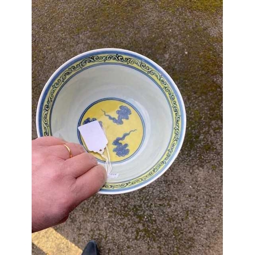 691 - A CHINESE MING STYLE YELLOW-GROUND BLUE AND WHITE 'DRAGON' BOWL painted with twin dragons chasing fl... 