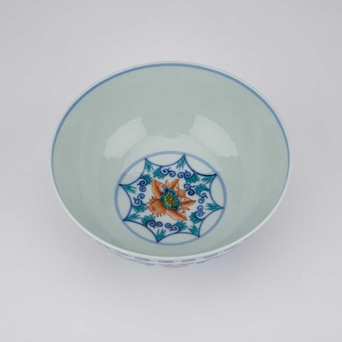 692 - A CHINESE DOUCAI 'LOTUS' BOWL enamelled around the exterior with six large lotus heads born on leafy... 