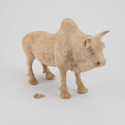 694 - A STRAW-GLAZED FIGURE AND A POTTERY MODEL OF AN OX Sui and Tang Dynasties, the figure standing with ... 