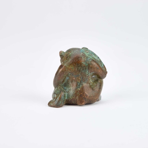 709 - A CHINESE BRONZE HAN-STYLE BEAR modelled sat with one knee raised. 5cm high