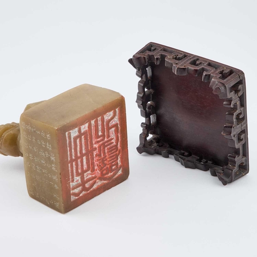 718 - A CHINESE SOAPSTONE TABLE SEAL square, surmounted by the carved figure of a Buddhist lion, inscribed... 