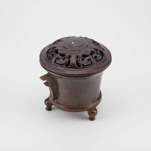 727 - A CHINESE BRONZE TRIPOD CENSER with a carved and pierced cover, bears cast mark. 12.5cm high