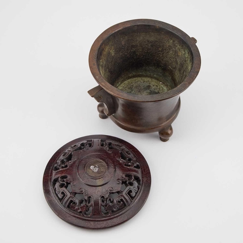 727 - A CHINESE BRONZE TRIPOD CENSER with a carved and pierced cover, bears cast mark. 12.5cm high