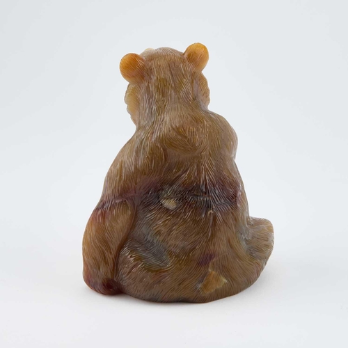 825 - A RUSSIAN AGATE MODEL OF A BEAR carved sitting and licking a raised paw, the open mouth displaying w... 