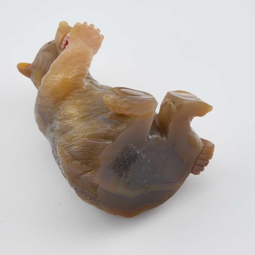 825 - A RUSSIAN AGATE MODEL OF A BEAR carved sitting and licking a raised paw, the open mouth displaying w... 