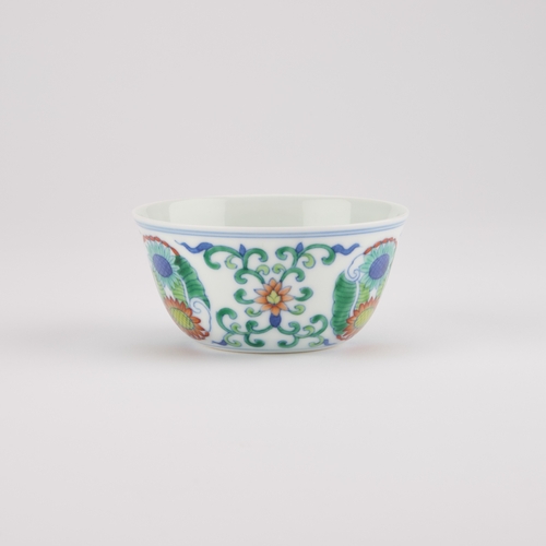 106 - A CHINESE DOUCAI CUP decorated with three floral medallions, bears an underglaze blue six-character ... 