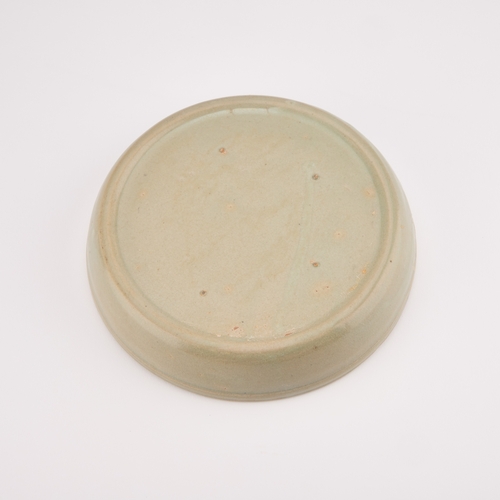 119 - A CHINESE CELADON BRUSH WASHER circular, moulded in relief with a Kylin. 17.5cm diameter