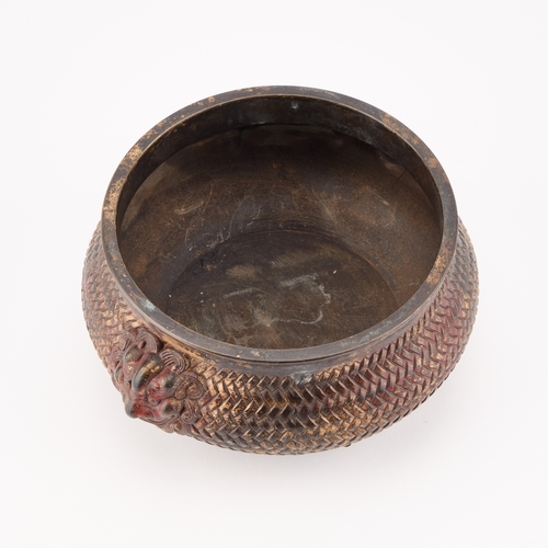 145 - A CHINESE BRONZE CENSER of squat form, with a basketweave exterior and twin lion-mask handles, bears... 