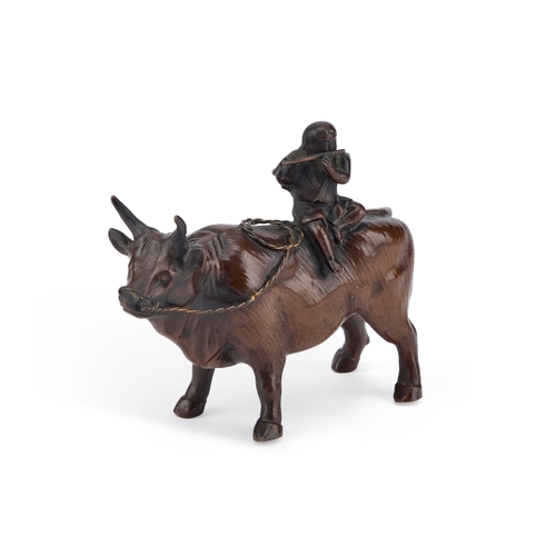 152 - A JAPANESE BRONZE MODEL OF A BULL atop his back a small boy sitting playing a flute. 13.5cm long... 