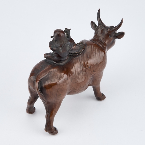 152 - A JAPANESE BRONZE MODEL OF A BULL atop his back a small boy sitting playing a flute. 13.5cm long... 
