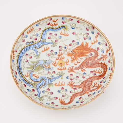 77 - A CHINESE IRON-RED AND ENAMEL 'DRAGON' DISH painted with two dragons and a flaming pearl, bears an u... 