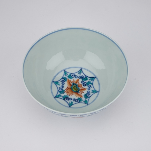 78 - A CHINESE DOUCAI 'LOTUS' BOWL enamelled around the exterior with six large lotus heads born on leafy... 