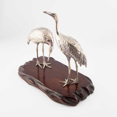 144 - A JAPANESE SILVERED BRONZE OKIMONO OF TWO CRANES Meiji period (1868-1912), signed, on a wooden base.... 