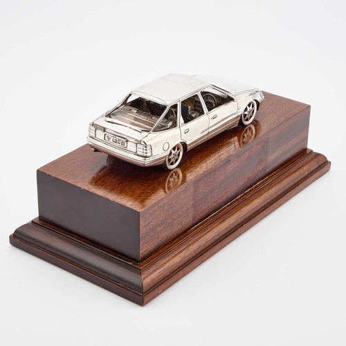 310 - AN ELIZABETH II SILVER MODEL OF A FORD SCORPIO CAR by Garrard & Co Ltd, London 1989, on a wooden... 