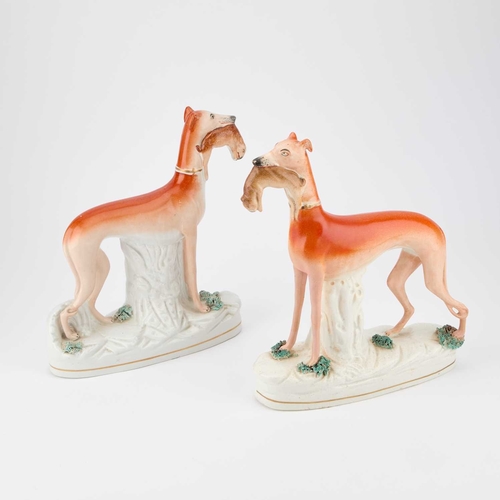 63 - A NEAR PAIR OF VICTORIAN STAFFORDSHIRE POTTERY MODELS OF GREYHOUNDS together with a pair of pottery ... 