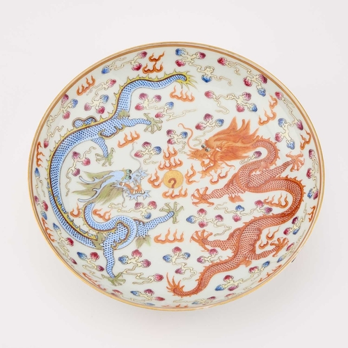 87 - A CHINESE IRON-RED AND ENAMEL 'DRAGON' DISH painted with two dragons and a flaming pearl, bearing an... 