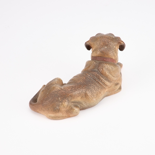 38 - AN AUSTRIAN PAINTED TERRACOTTA MODEL OF A RECUMBENT DOG late 19th Century. 19.5cm long