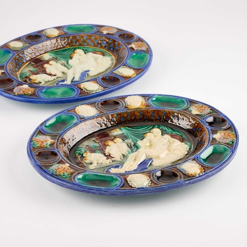 105 - A PAIR OF CONTINENTAL MAJOLICA OVAL DISHES each moulded with Classical figures. (2) 25.5cm long... 