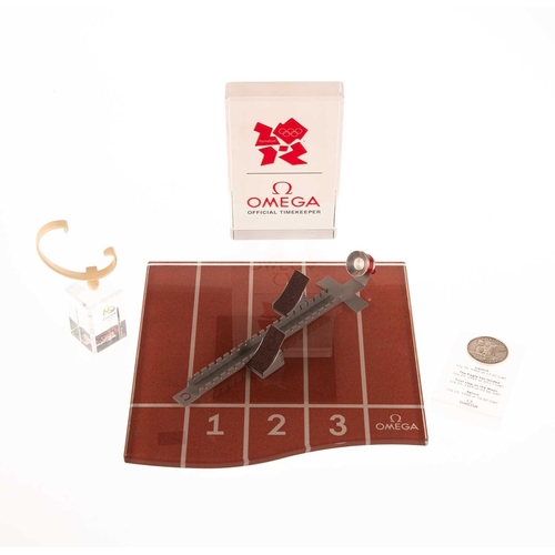 330 - A GROUP OF OMEGA WATCH DISPLAY ITEMS comprising an Olympic Games starting block display stand with a... 