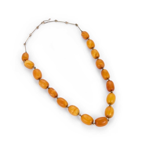 335 - AN AMBER BEAD NECKLACE the seventeen oval polished amber beads strung uniform on to articulated meta... 