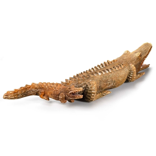 361 - A LARGE AND UNUSUAL CARVED WOODEN CROCODILE modelled with juvenile. 89cm long