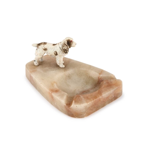 363 - AN ART DECO PAINTED METAL AND ONYX ASHTRAY mounted with the figure of a spaniel. 11.5cm long