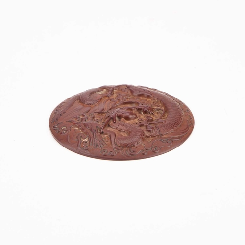 134 - A 'DRAGON' ROUNDEL convex, decorated in relief with a dragon. 8cm diameter