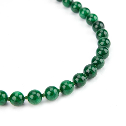 151 - A STRING OF JADEITE BEADS the uniform beads strong knotted. 38cm long