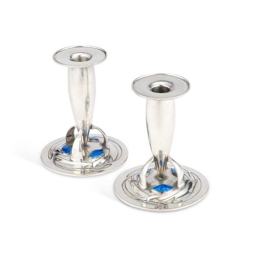 184 - ARCHIBALD KNOX (1864-1933) FOR LIBERTY & CO, A PAIR OF TUDRIC PEWTER AND ENAMEL CANDLESTICKS the tor... 