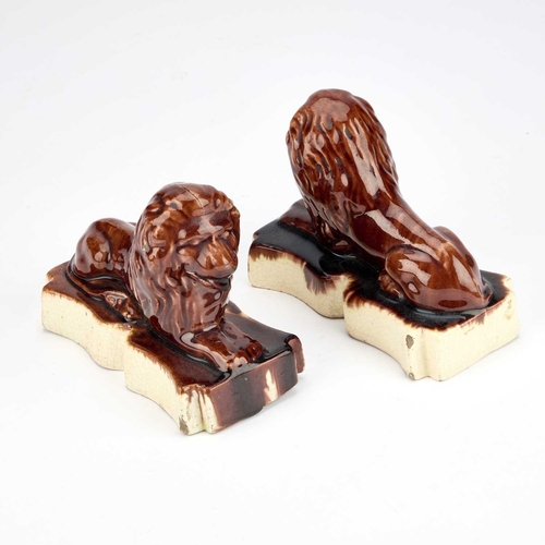 24 - A PAIR OF VICTORIAN TREACLE-GLAZED POTTERY MODELS OF RECUMBENT LIONS (2) 14.5cm long