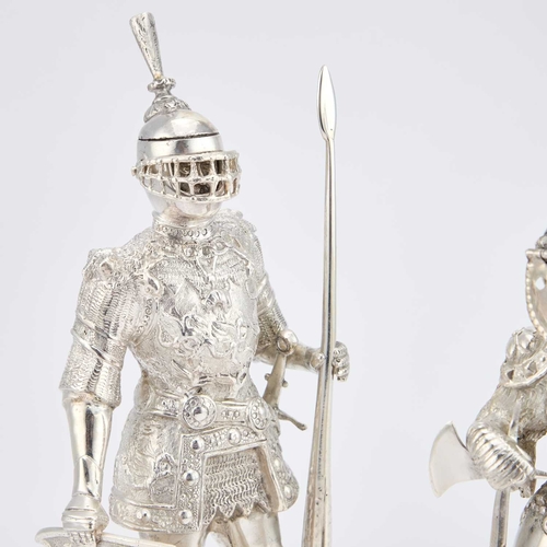 251 - A PAIR OF CONTINENTAL SILVER FIGURES OF STANDING KNIGHTS modelled in full armour, each holding a shi... 