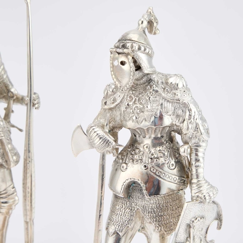 251 - A PAIR OF CONTINENTAL SILVER FIGURES OF STANDING KNIGHTS modelled in full armour, each holding a shi... 