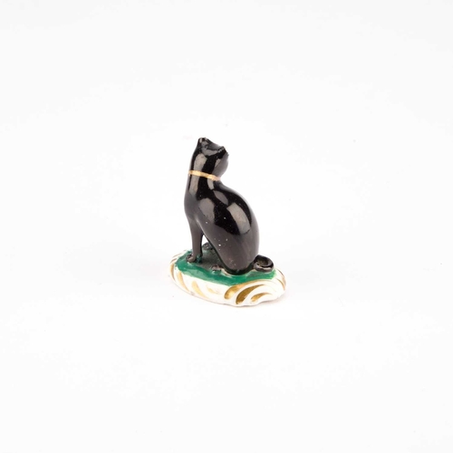 28 - A RARE ROCKINGHAM MODEL OF A CAT the black feline seated on a green base with an oval Rococo moulded... 