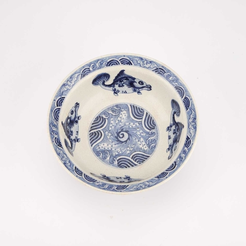 77 - A BLUE AND WHITE BOWL IN SOFT PASTE decorated along the well with four large fish. 20.5cm diameterBo... 