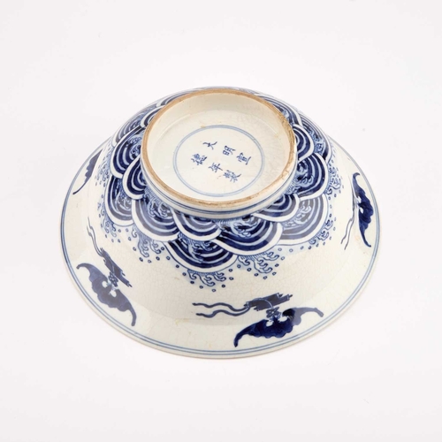 77 - A BLUE AND WHITE BOWL IN SOFT PASTE decorated along the well with four large fish. 20.5cm diameterBo... 