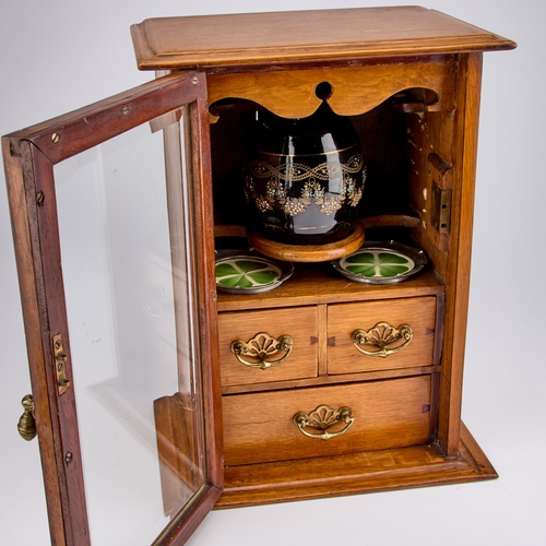 233 - AN EDWARDIAN OAK SMOKERS CABINET the interior with a tobacco jar and pair of ashtrays. 39.5cm high... 