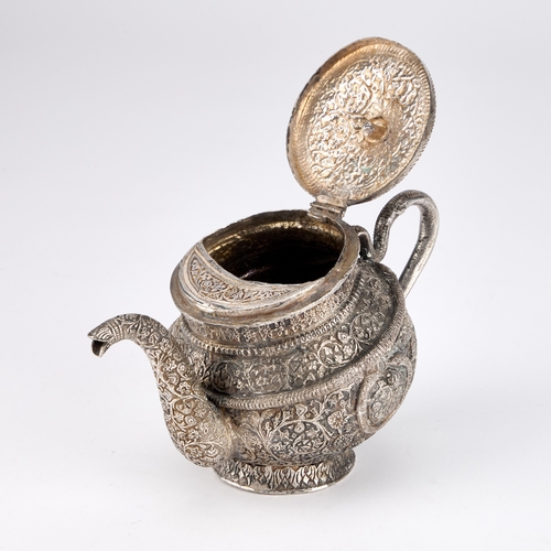 334 - AN INDAN KASHMIRI SILVER TEAPOT of tipped kang form, chased Kutch pattern with segments and floral f... 