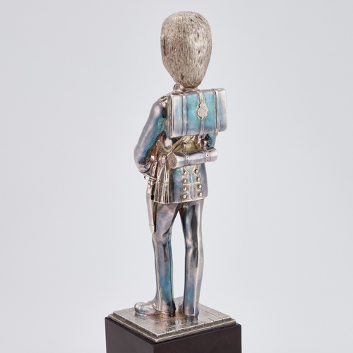 465 - AN UNMARKED FIGURE OF A GRENADIER GUARD modelled standing, raised on an ebonised plinth. 35.5cm high... 