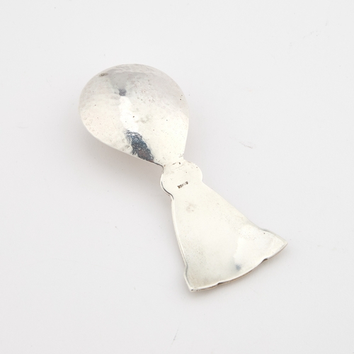 482 - AN IONA SILVER CADDY SPOON the lightly planished bowl with an embossed Celtic design handle. 8cm lon... 